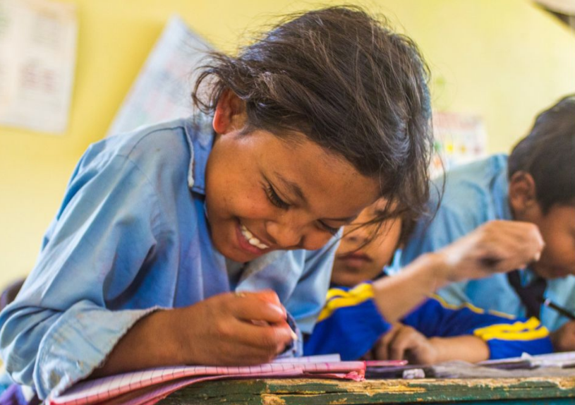 A woman looking very distressed in front of a building damaged by bombing